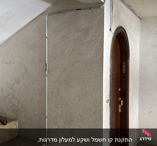 תמונה של קיר עם צינורות חשמל ודלת עץ